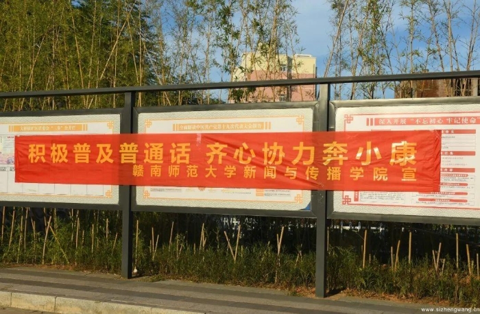 12-志愿者们在公告牌上都张贴推广普通话的横幅_UUID11357