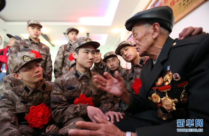 柴云振给来家中探望、即将启程奔赴军营的新兵们讲述战斗故事(资料照片)。<span style=